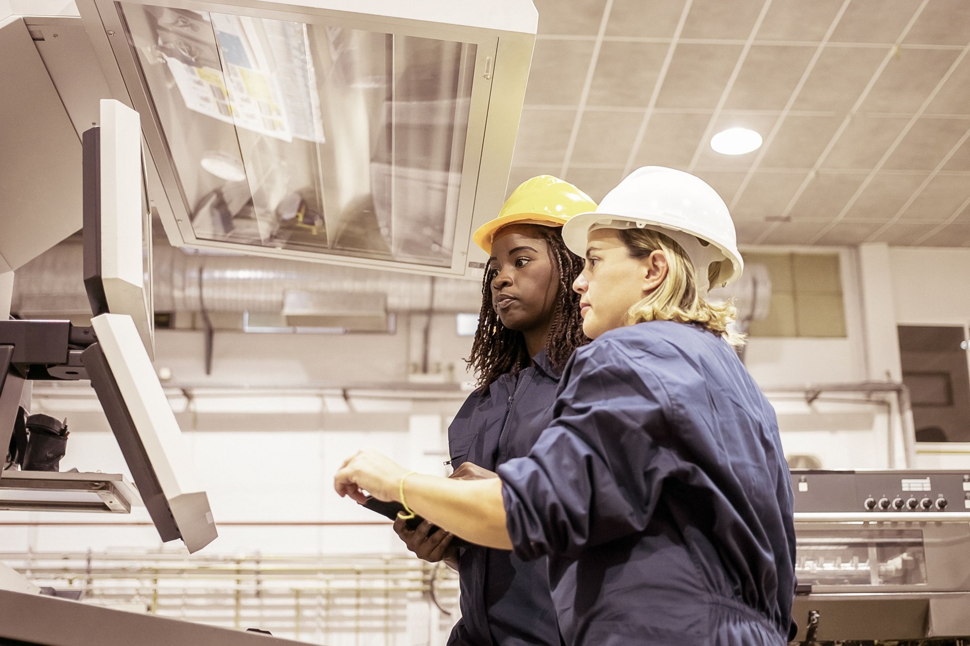 Diversas trabalhadoras industriais operando máquina